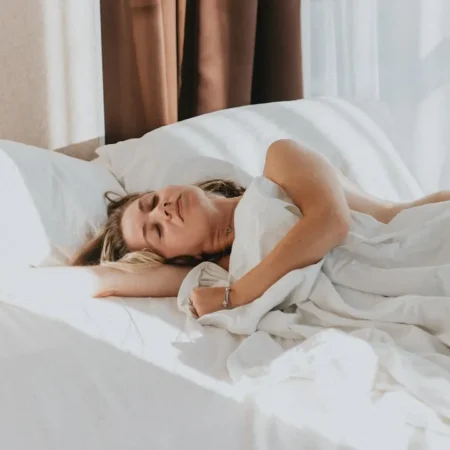 Frau schläft entspannt im Bett – erholsamer Schlaf dank 4-7-8 Atemtechnik