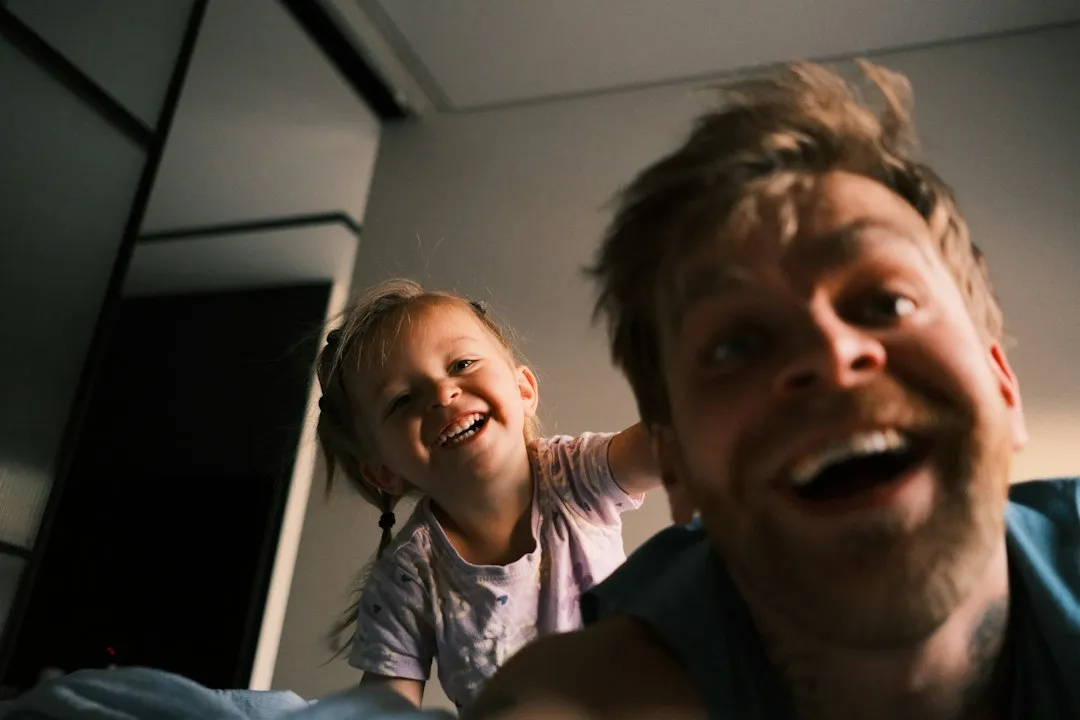 Vater und Kind lachen gemeinsam – zusammen über Kinderwitze lachen