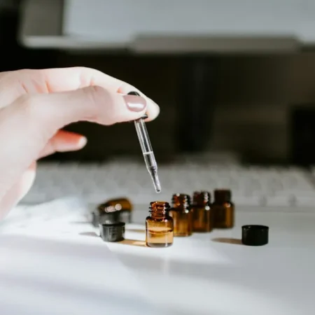 Braunes Fläschchen mit ätherischem Öl auf einem Tisch – ätherische Öle bei Erkältung richtig anwenden
