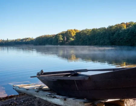 Ruderboot an einem Steg am nebligen See – eine ruhige Auszeit am Morgen