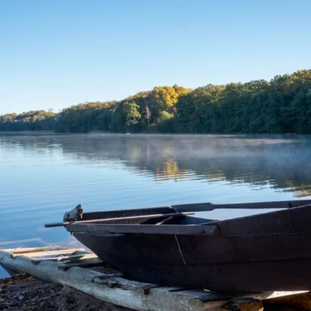 Ruderboot an einem Steg am nebligen See – eine ruhige Auszeit am Morgen