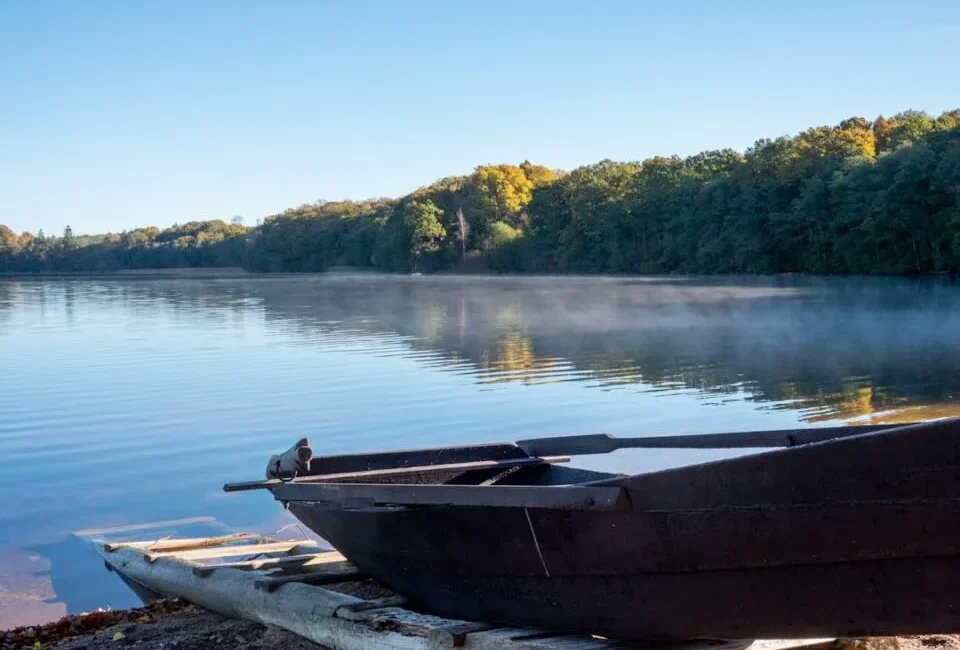Ruderboot an einem Steg am nebligen See – eine ruhige Auszeit am Morgen