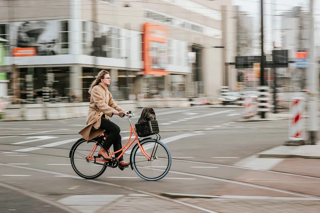 Junge Frau fährt mit dem Rad durch die Stadt – mit dem Fahrrad zur Arbeit ist gesund und klimafreundlich